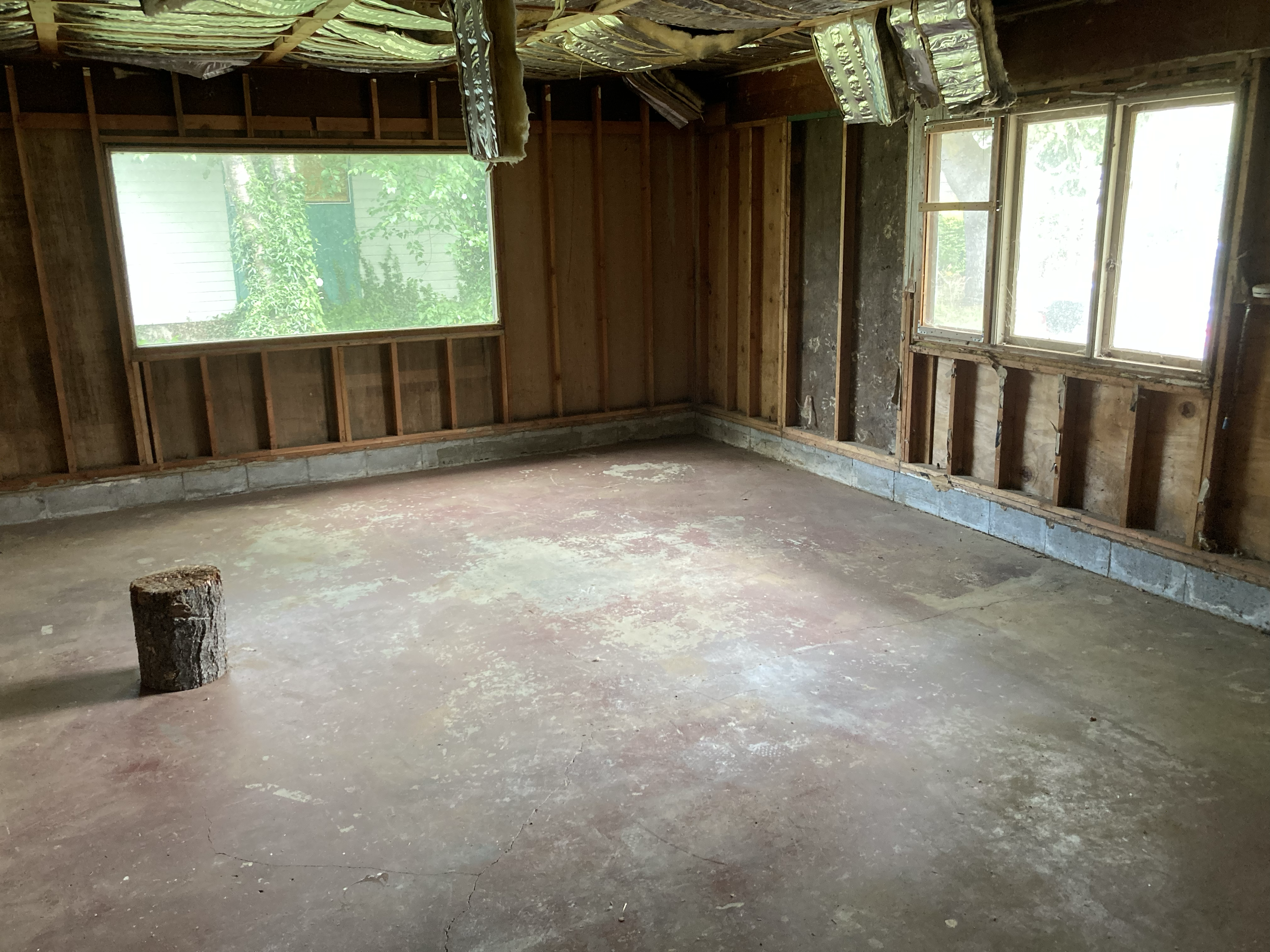 3017 Galvin Road garage, before conversion — stripped to the studs, bare concrete slab, exposed framing